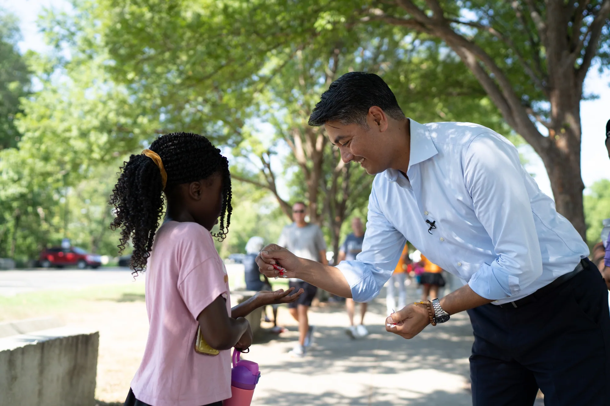 A campaign candidate meeting a young community member outdoors